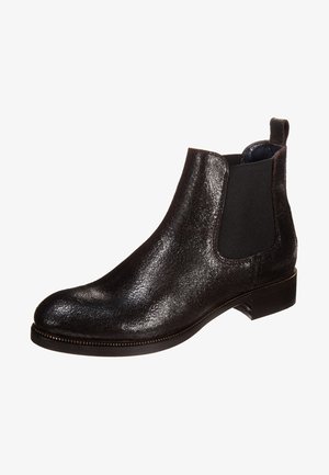 Bottine Chelsea en cuir noir avec des panneaux élastiques sur les côtés et un petit talon empilé, dotée d'une languette à l'arrière.