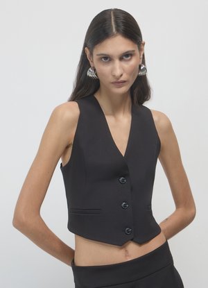 Veste noire sans manches avec un col en V profond, fermeture à cinq boutons, deux poches avant, coupe ajustée et texture de tissu lisse.