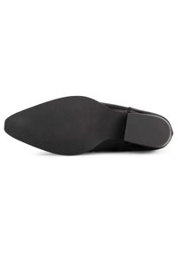 Zapato de cuero negro con una punta afilada y una suela plana y lisa. Diseño minimalista sin patrones visibles ni acentos de hardware.