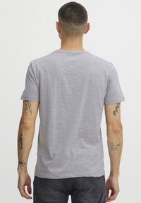 Grå kortermet T-skjorte laget av myk stoff, med klassisk rund hals og avslappet passform, med ensfarget bakside og uten synlige logoer.