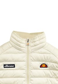 Wy�ściełana kremowa kurtka z wysokim kołnierzem, przednim zamkiem błyskawicznym i czarnym logo "ellesse". Posiada kolorową naszywkę z logo na klatce piersiowej. Gładka faktura.
