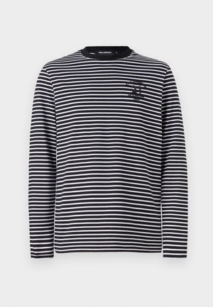 Long-sleeve striped shirt in black and white, made of soft fabric; features a round neck and a small logo on the chest.