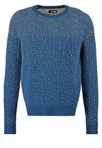 Blå tröja med rund halsringning, prydd med ett texturerat mönster av små vita prickar över hela. Långa ärmar och ribbade manschetter och nederkant.