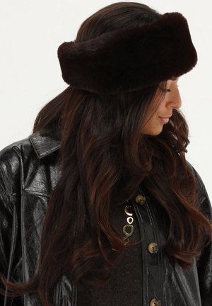 Brown faux fur headband with a wide design, featuring a smooth texture and rounded shape, worn alongside a shiny black leather jacket.