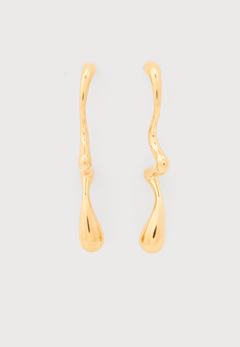 Ασύμμετρα χρυσά σκουλαρίκια με σταγόνες, με ρευστές, ακανόνιστες μορφές, που διαθέτουν ομαλές κυρτές γραμμές και άκρα σε σχήμα δάκρυου σε απλό λευκό φόντο.