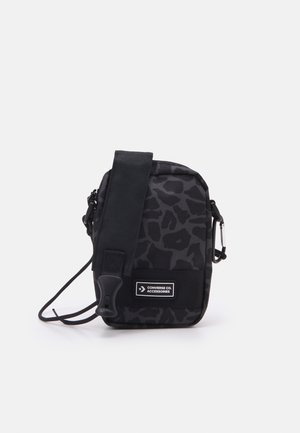 Schwarze Crossbody-Tasche mit Leopardenmuster, Reißverschluss, verstellbarem Riemen und Logopatch. Hergestellt aus strapazierfähigem Stoff mit glatter Textur.