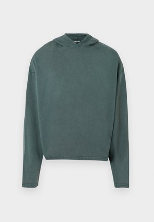 Bluza z kapturem w stonowanej zielonej kolorystyce, wykonana z miękkiego materiału, o luźnym kroju i długich rękawach, z prążkowanym dołem i mankietami.