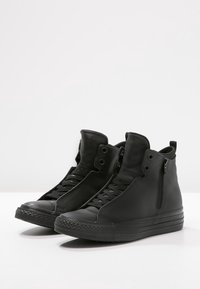 Schwarze High-Top-Sneaker aus Leder, mit Schnürung vorne, einem seitlichen Reißverschluss, strukturiertem Zehenbereich und einem glatten Finish mit flacher Sohle.