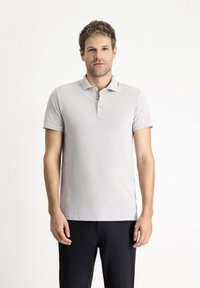 Hellgraues Poloshirt aus glattem Stoff mit Kragen, kurzen Ärmeln und einer Knopfleiste mit drei Knöpfen.