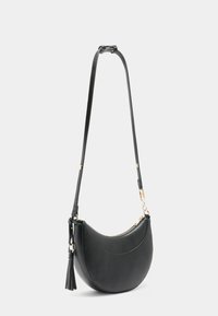 Borsa a tracolla nera in pelle con forma a mezzaluna, superficie texturizzata, chiusura con zip e dettaglio decorativo con nappina. Cinghia regolabile.