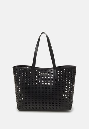 Schwarze, perforierte Tragetasche mit zwei langen Henkeln und "HUGO"-Logo auf der Vorderseite, vor einem schlichten weißen Hintergrund.