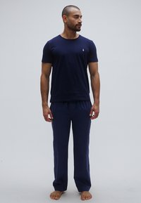 Námornícka modrá bavlnená tričko s krátkymi rukávmi a okrúhlym výstrihom, doplnené o zodpovedajúce pyžamové nohavice s elastickým pásom.