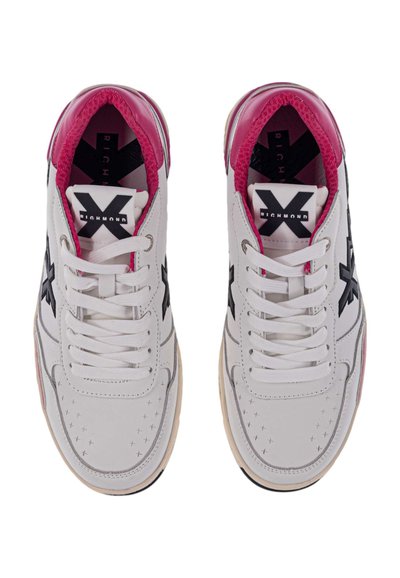 Sneakers bianchi con accenti rosa e logo nero, caratterizzati da dettagli perforati, punta rotonda e lacci bianchi. Parte superiore in pelle liscia.