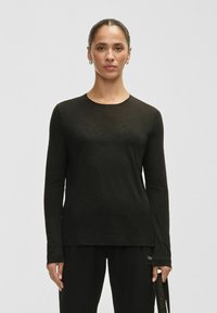 Black long-sleeve shirt in a lightweight fabric with a round neckline. Features a relaxed fit and subtle texture throughout.