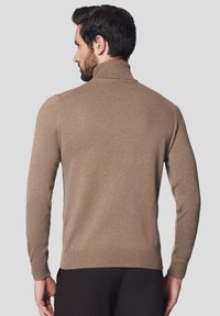 Brązowy sweter z golfem o dopasowanym kroju, z prążkowanymi mankietami i dołem, wykonany z miękkiego materiału. Widok z tyłu pokazuje gładki, bezszwowy design.