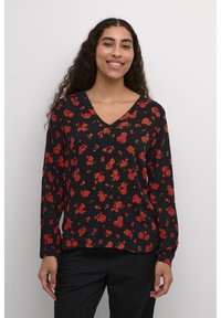 Zwarte blouse met lange mouwen, met een V-hals en rode bloemenpatronen; lichte stof met een relaxte pasvorm en elastische manchetten.
