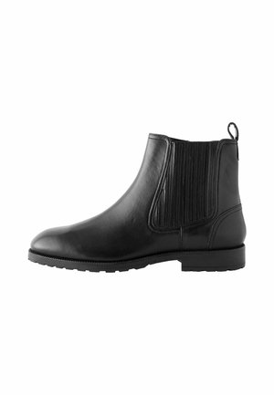 Botín Chelsea de cuero negro con paneles laterales elásticos, una lengüeta, puntera redonda y suela de goma texturizada para mayor agarre.