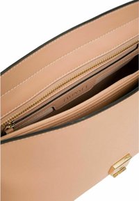 Interno di una borsa in pelle rosa con una tasca con zip. Presenta hardware dorato e bordi neri a contrasto. Texture liscia, design minimalista.