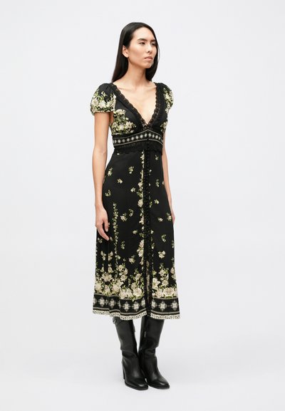 Zwarte bloemenjurk met een diepe V-hals, korte pofmouwen, verfijnde kanten rand en een vloeiende rok met een bloemenpatroon en kantaccenten.