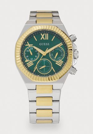 Montre en métal argenté et doré avec un cadran vert texturé, des index heures dorés, trois sous-cadrans et un design de lunette octogonale.