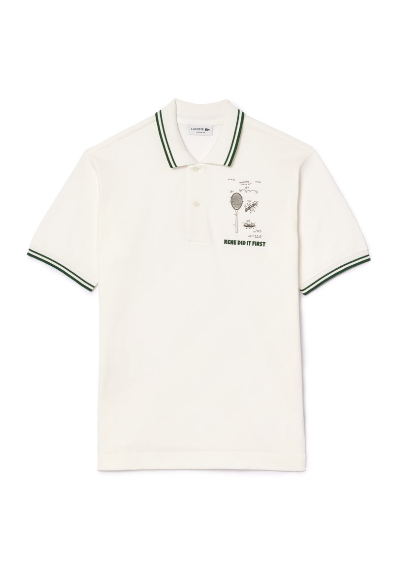 Polo shirt Lacoste blanc avec des rayures vertes doubles sur le col et les manches, comportant un croquis de raquette de tennis et le texte "RENE L'A FAIT EN PREMIER".