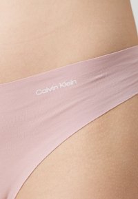 Rosa Baumwoll-Minimal-Bikiniunterwäsche mit einem weichen Bund, der das "Calvin Klein"-Logo in Weiß trägt. Glatte Textur und keine sichtbaren Nähte.