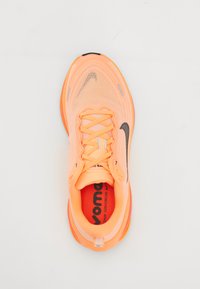 Leuchtend orange und rosa Nike-Laufschuh mit reflektierenden Details und schwarzem Swoosh, von oben auf einem weißen Hintergrund betrachtet.