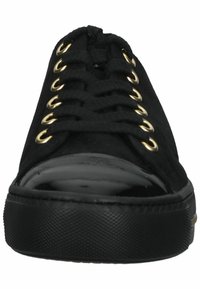 Schwarze Sneaker mit einer glatten Lackzehenkappe, Obermaterial aus Stoff und goldenen Ösenakzenten an der Schnürung. Gummisohle mit strukturiertem Oberflächen.