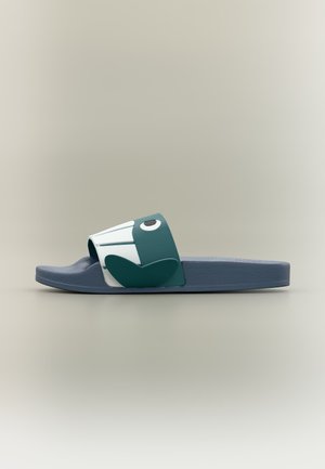 Einzelne blaue Rutschpantoffel mit einem breiten Riemen, der ein stilisiertes Vogelgesicht und Flügelmuster auf einem neutralen Hintergrund zeigt.