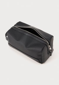 Black leather toiletry bag with a rectangular shape, textured surface, and a silver zipper. Side handle for easy carrying.
