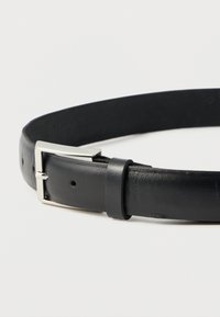 Ceinture en cuir noir dotée d'une boucle rectangulaire en métal argenté et de trous renforcés pour l'ajustement, avec une finition lisse et un design élégant.