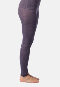 Lila Leggings aus weichem, strukturiertem Stoff mit einer figurbetonten Passform, die bis zu den Knöcheln reicht, gezeigt an einem baren Fuß.