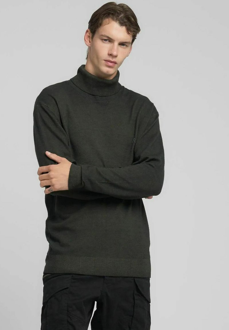 Jersey de cuello alto verde oscuro de tejido de punto, con cuello y puños acanalados, ajuste relajado y un logo sutil en el pecho.