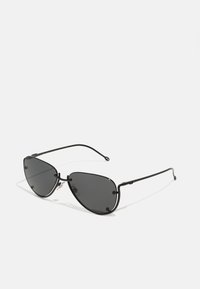 Lunettes de soleil en métal noir avec un design angulaire en œil de chat, verres teintés et branches fines. Comprend des plaquettes de nez pour le confort et une finition élégante.