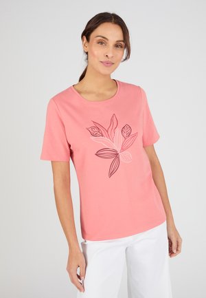 T-shirt rosa a maniche corte con un motivo di foglie botaniche in tonalità più scure. Scollo tondo, tessuto morbido e vestibilità comoda.