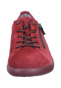Red suede sneaker featuring textured upper, black lace detailing, side zipper, and a round rubber sole.