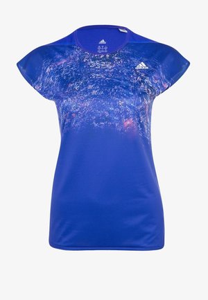 Camiseta deportiva azul con mangas tipo capa y estampado abstracto, combinada con leggings oscuros que tienen franjas grises y diseño ajustado.