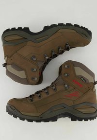 Braune Wanderschuhe mit einem strukturierten Leder- und Mesh-Obermaterial, Gummisohle und Metallbeschlägen. Sie verfügen über ein hohes Knödes-Design für zusätzlichen Halt.