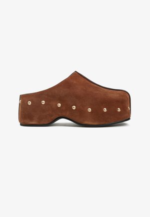 Brązowy platformowy chodak z zamszu z zaokrąglonym noskiem i złotymi ćwiekami wzdłuż boku i pięty na czarnej podeszwie.