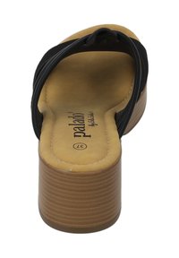 Tongs noires avec un talon chunky et rainuré beige. Semelle intérieure douce beige avec logo de la marque, présentant des lanières croisées pour un meilleur maintien.
