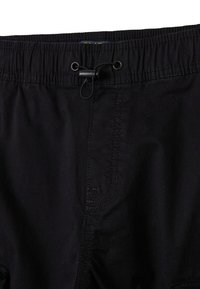 Zwarte shorts met een elastische tailleband, een verstelbaar trekkoord en zichtbare stikdetails. De stof lijkt lichtgewicht en glad.