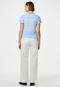 Ljust blått ribbat linne med vita ränder, korta volangärmar. Kombinerat med benvita vida byxor och svarta skor.