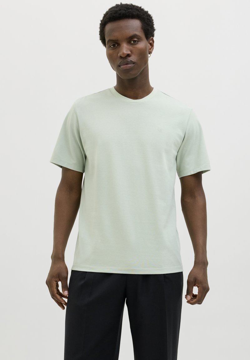 Lichtgroen T-shirt met korte mouwen en een ronde hals, gemaakt van zacht stof, met een subtiel logodetail op de borst.