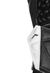 Black glove featuring textured black material, white accents, and geometric patterns, with distinct curved design elements.