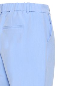 Lyseblå bukser med tekstureret stof, elastisk talje, sidelommer og en enkelt baglomme med kantdetalje.