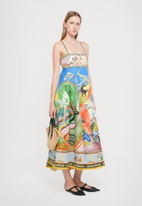 Rochie lungă, colorată, cu bretele spaghetti, având grafice și modele mixte. Fabricată dintr-un material ușor, cu o margine decorativă.