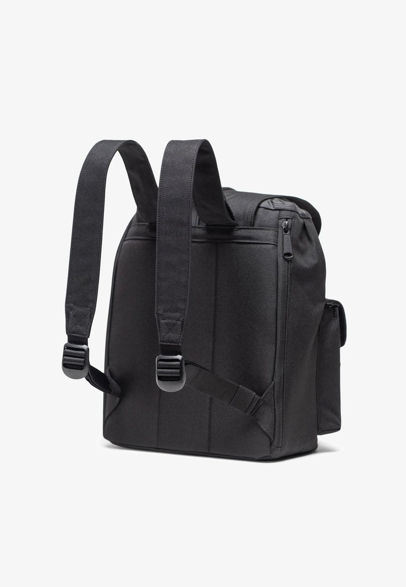 Mochila negra de tela durable, con correas ajustables acolchadas, un compartimento principal con cremallera y un bolsillo lateral.