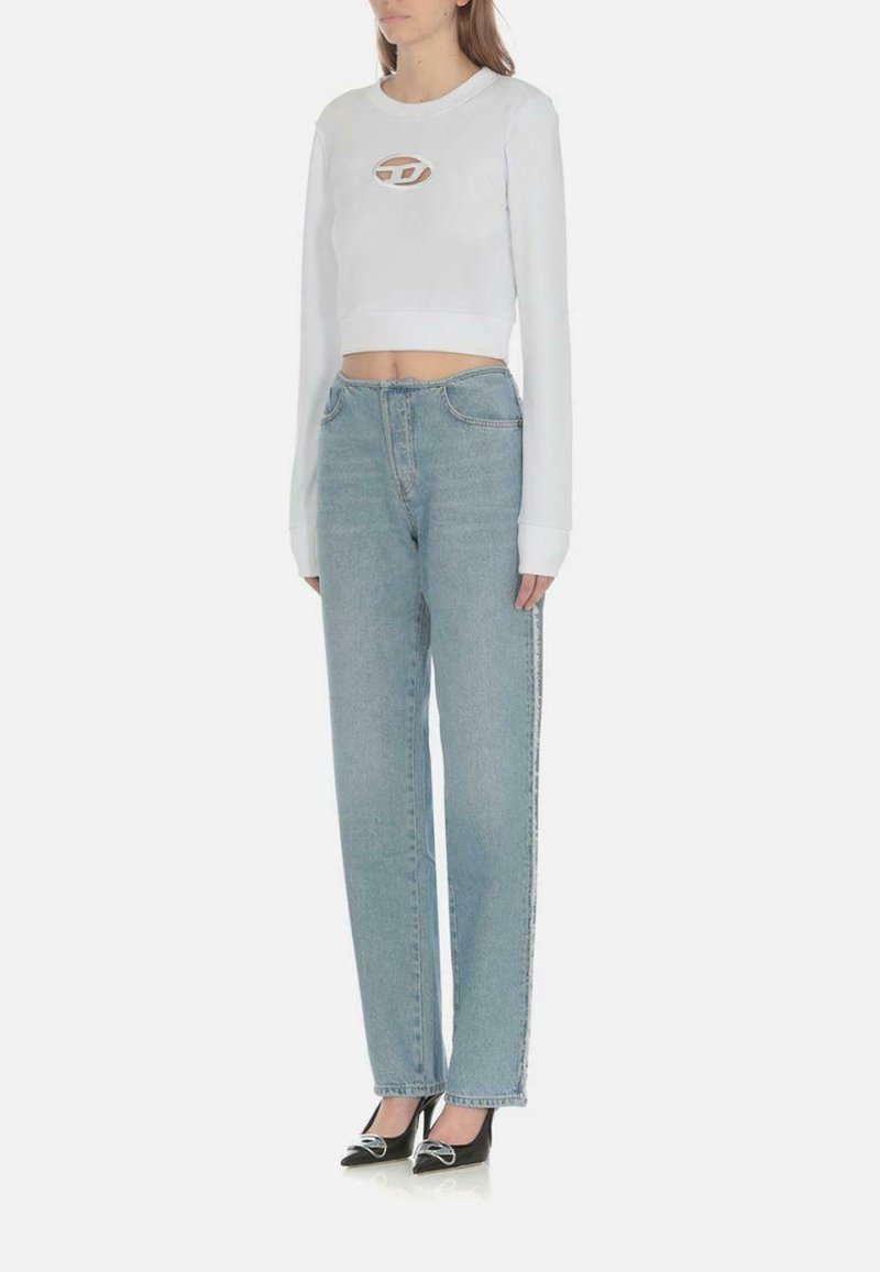 Felpa bianca corta con maniche lunghe e dettagli del logo, abbinata a jeans a vita alta dritti di colore blu chiaro e tacchi alti neri.
