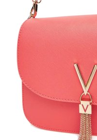 Sac à main en simili cuir rose corail avec un rabat, quincaillerie dorée et un accent en frange. Présente un détail de design en forme de "V".