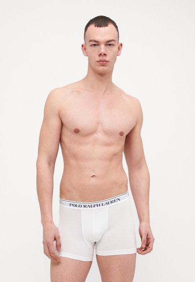 Boxers brancos feitos de algodão suave, com uma cintura elástica com marca em azul-marinho, apresentando o texto "POLO RALPH LAUREN".